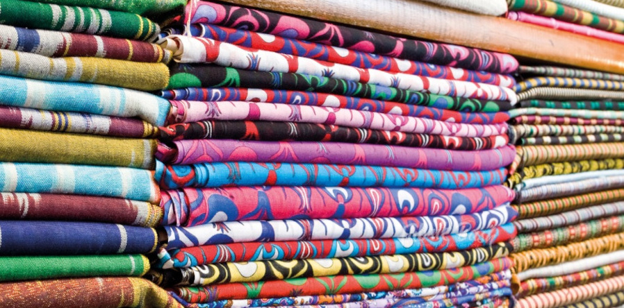 Mastering the art of organizing your fabric stash - three piles of folded and organized fabric