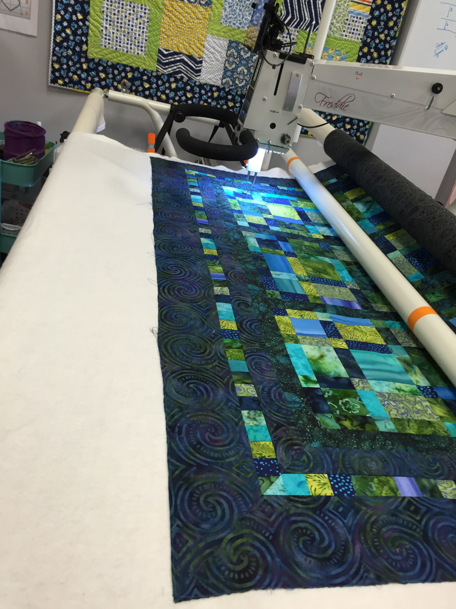 Bottom of batik quilt on the longarm frame